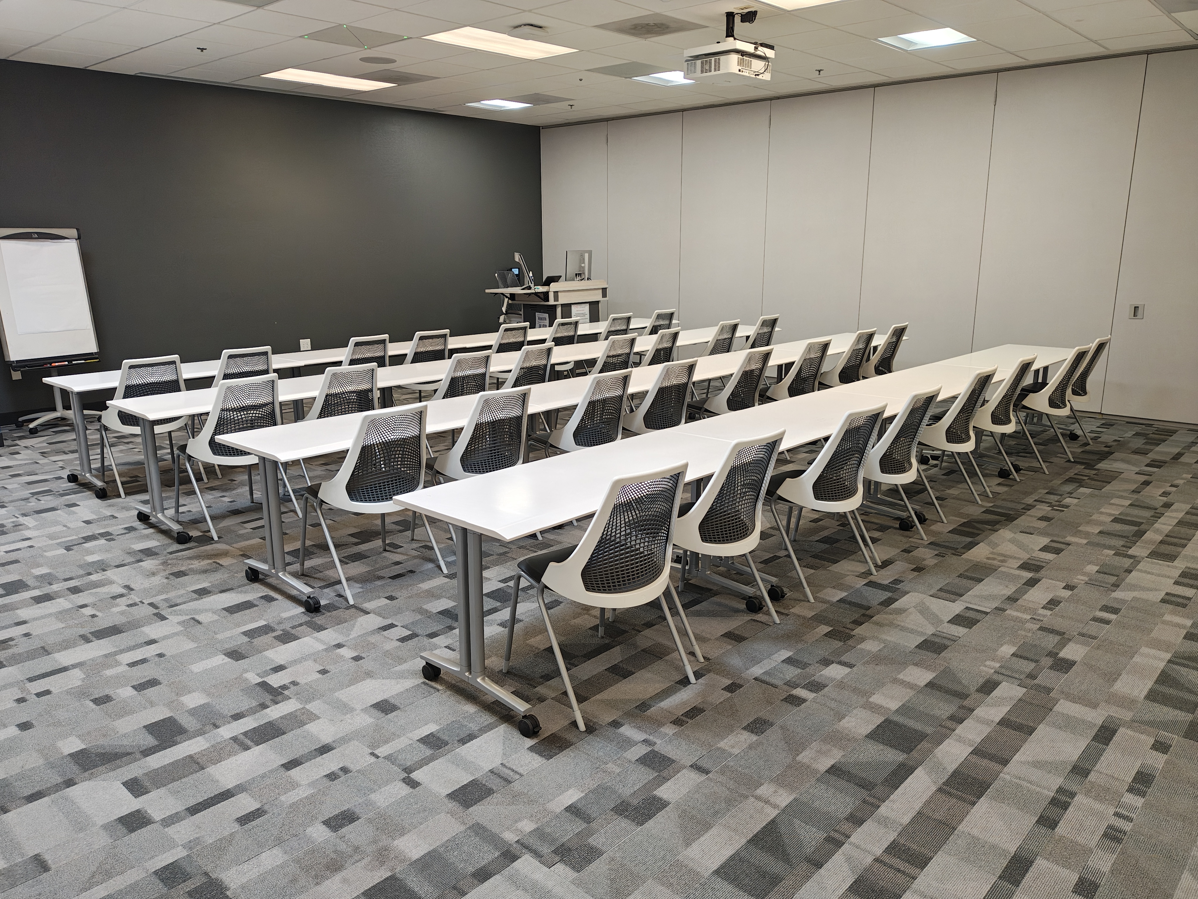 rows of tables and chairs in an empty classroom.