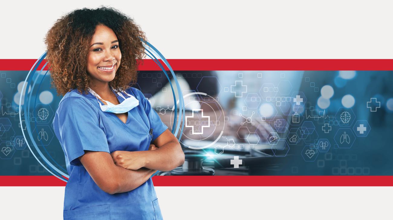 woman standing in blue scrubs with arms folded and smiling