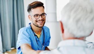 man sitting down with a patient in front of him