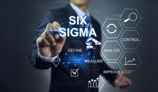 business man behind clear plexiglass board writing six sigma