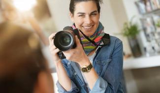 woman holding a camera in front of her chin