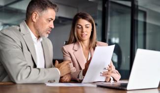 2 people at a desk discussing a legal paper file