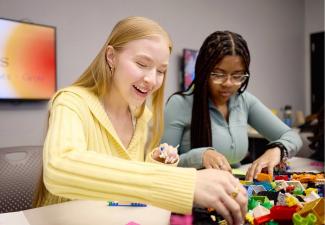 Teens playing with lego bricks